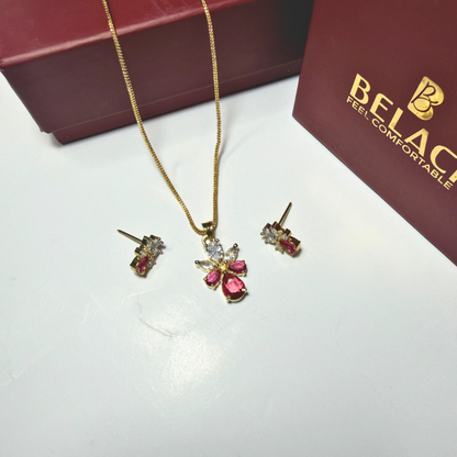 Jewelry set with necklace and earrings on a white surface next to a Belac box.