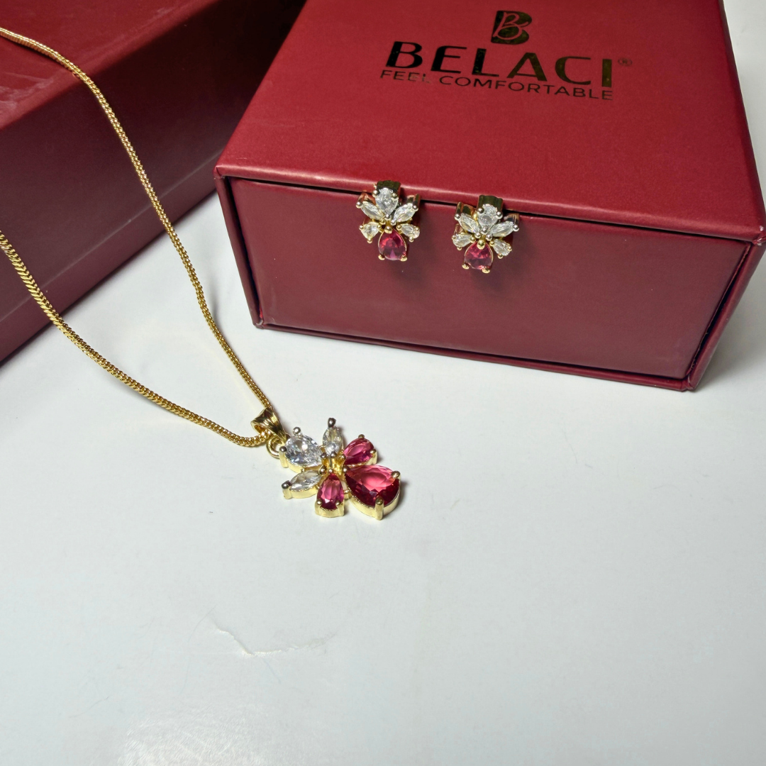Jewelry set with necklace and earrings on a white surface with a red BELACI box in the background.