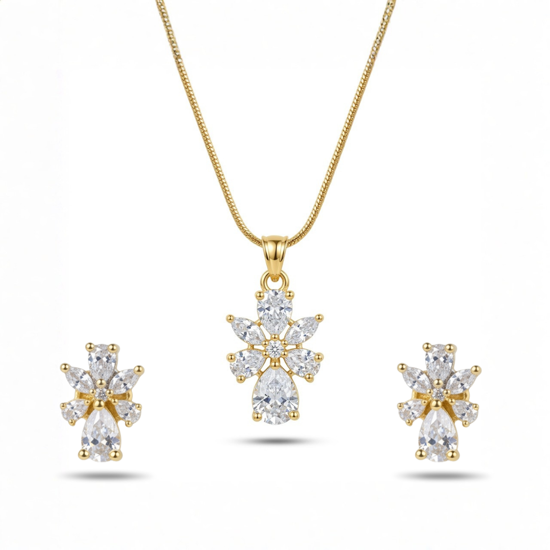 Gold necklace and earrings set with clear gemstones on a white background