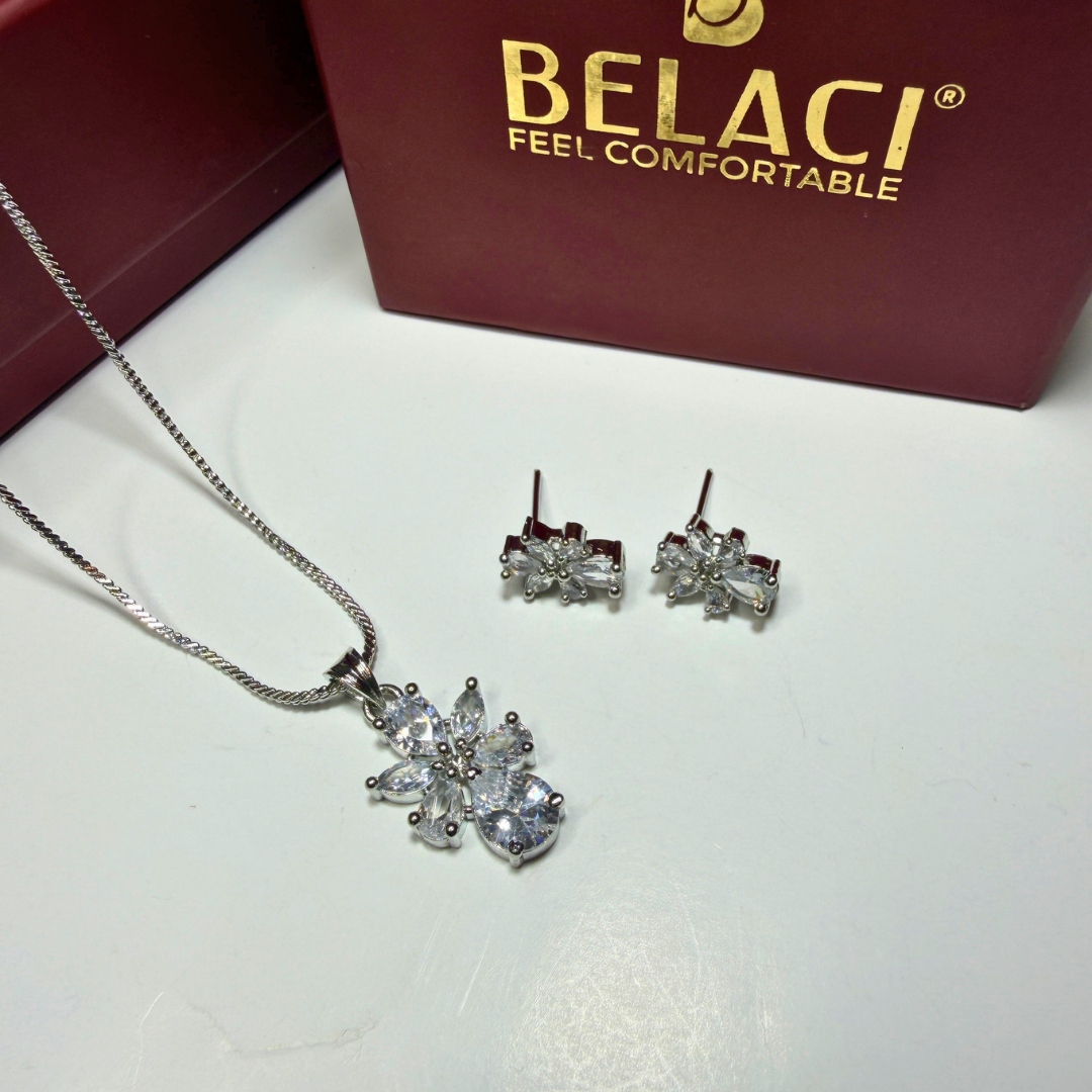 Jewelry set with necklace and earrings on a white surface, Belaci brand visible.