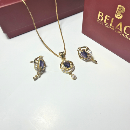 Jewelry set with necklace and earrings on a white surface with a Belac box in the background.