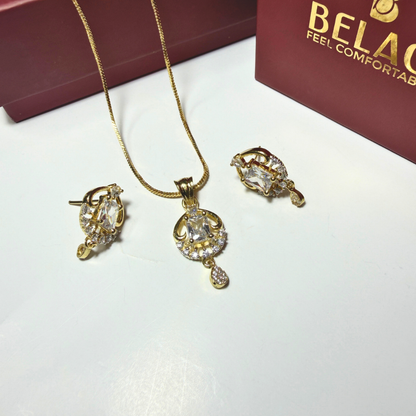 Gold jewelry set with necklace and earrings on a white surface, Beladora brand visible.