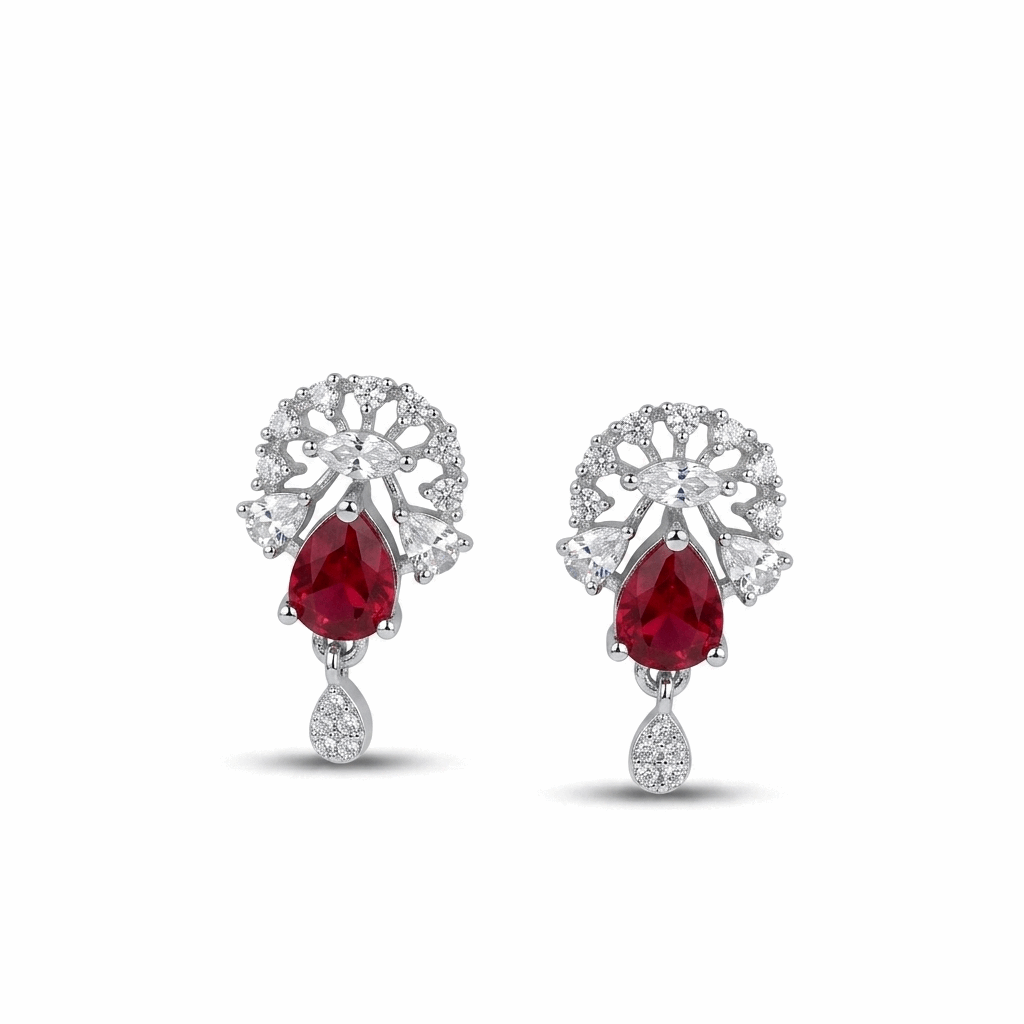 Pair of earrings with red gemstones and silver floral designs on a white background