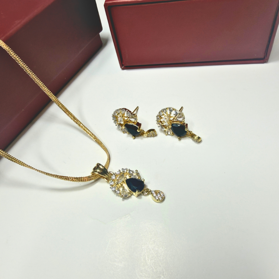 Gold necklace and earrings with black stones on a white surface