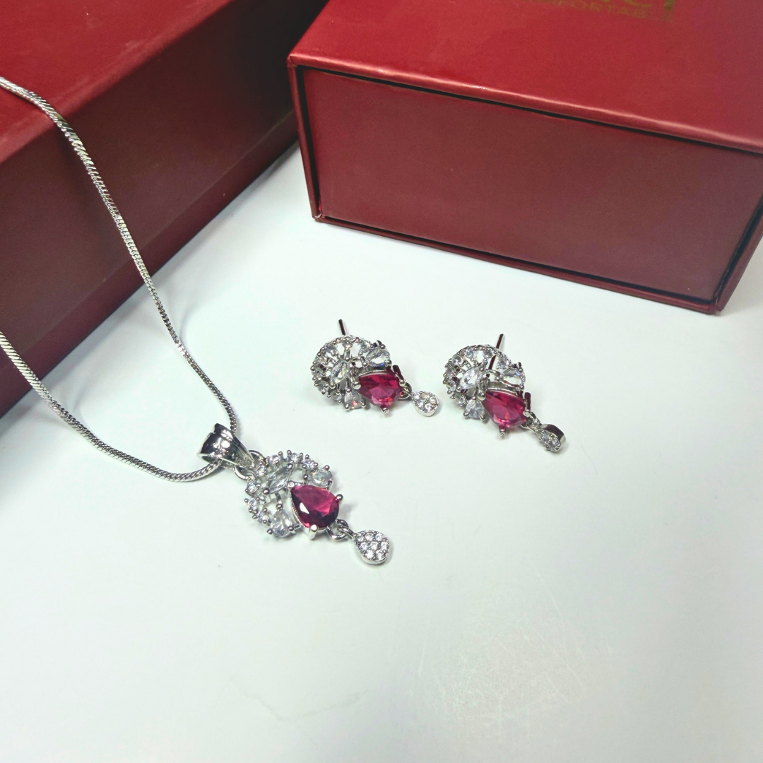 Jewelry set with heart-shaped gemstones on a white surface with a red box in the background.