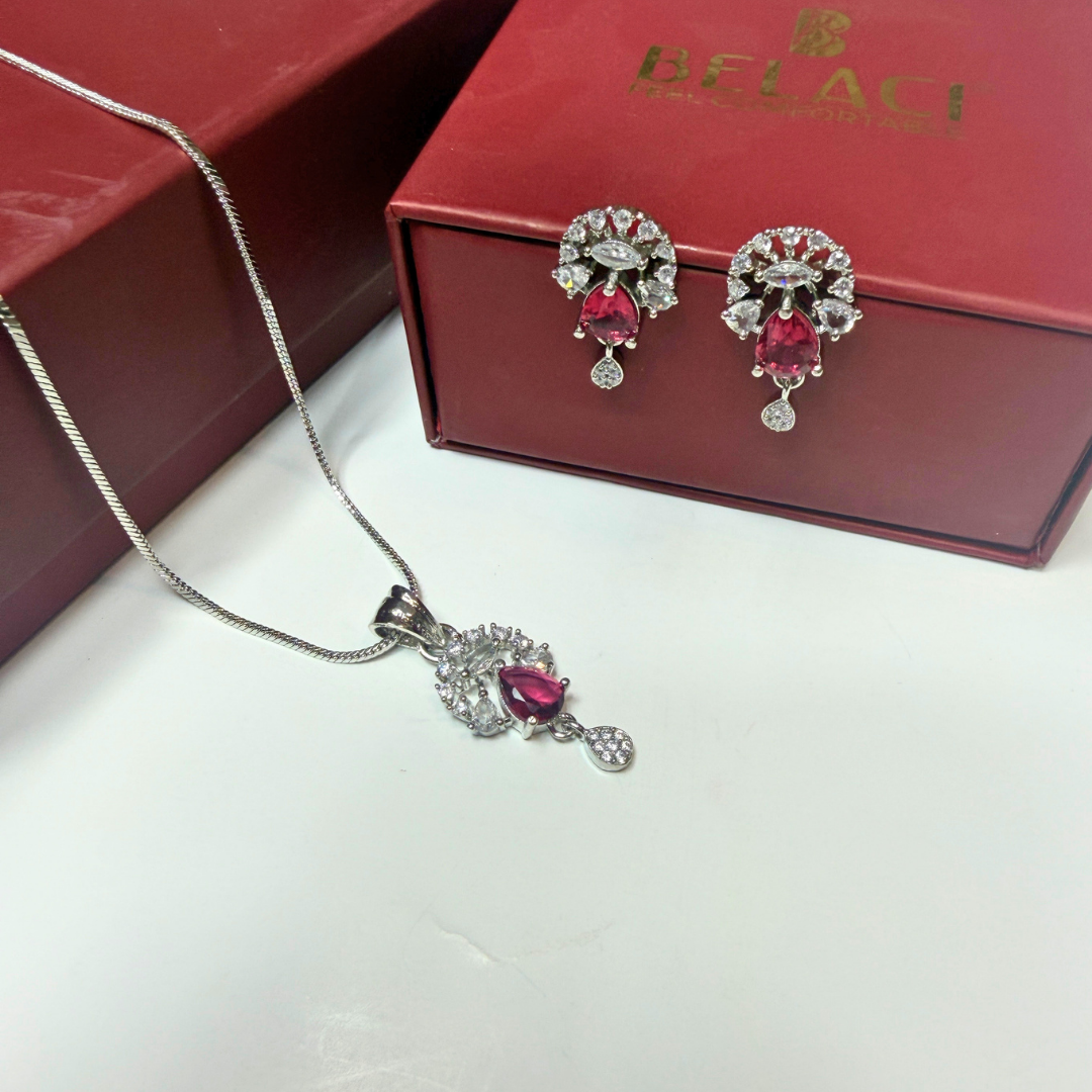 Jewelry set with pendant and earrings on a white surface with a Belaci box in the background.
