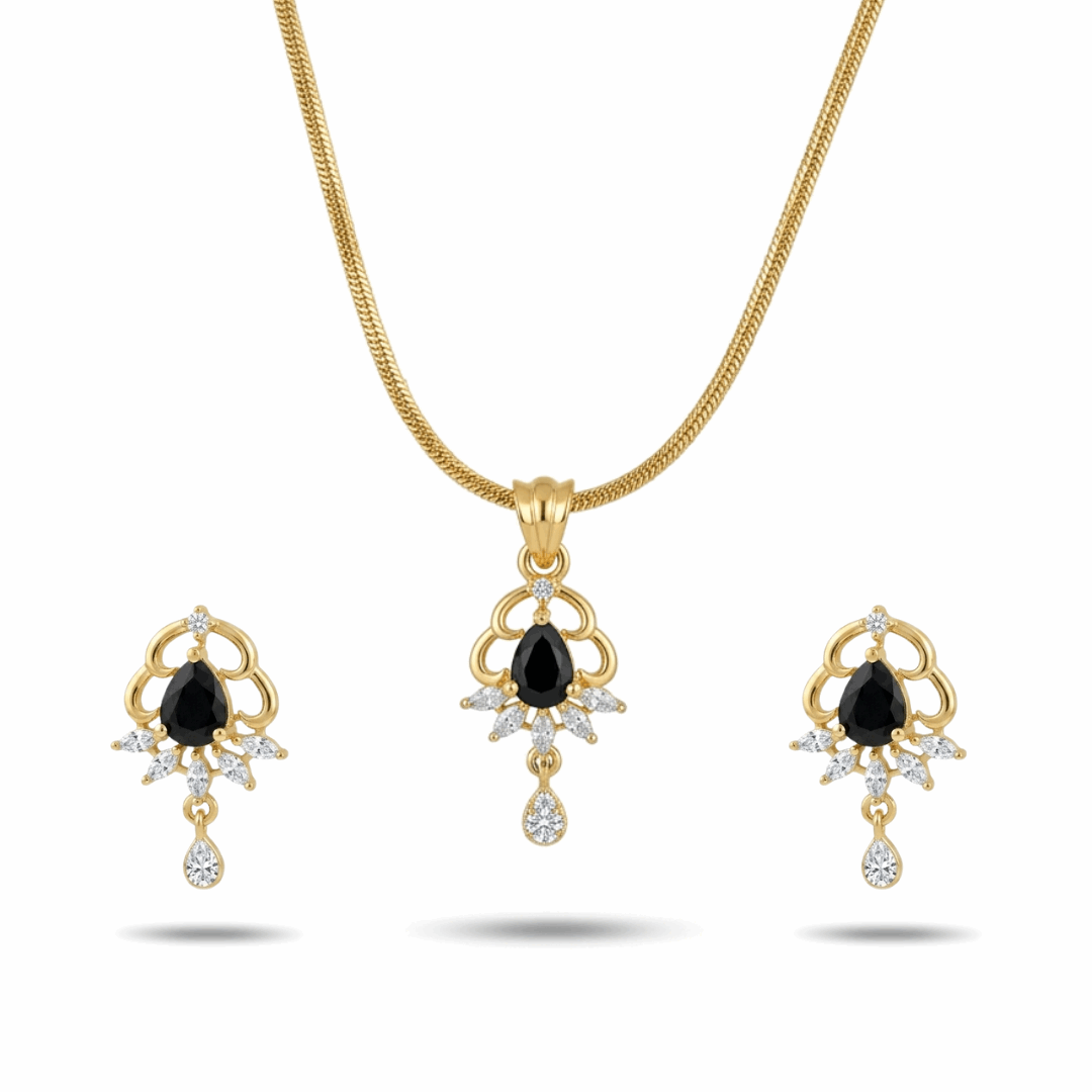 Gold necklace and earrings set with black gemstones on a white background