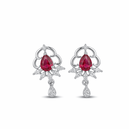 Pair of earrings with red gemstones and silver designs on a white background