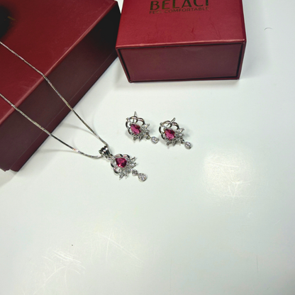Jewelry set with necklace and earrings on a white surface, Belaci box in the background.