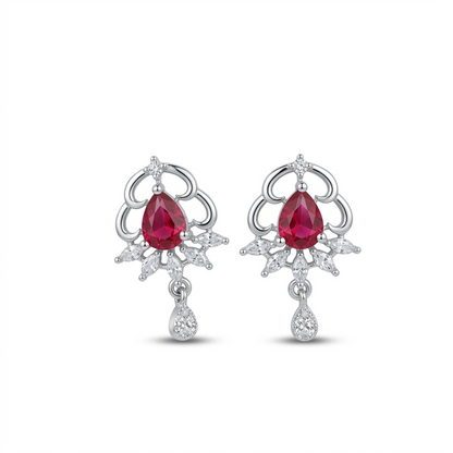 Pair of earrings with red gemstones and silver designs on a white background