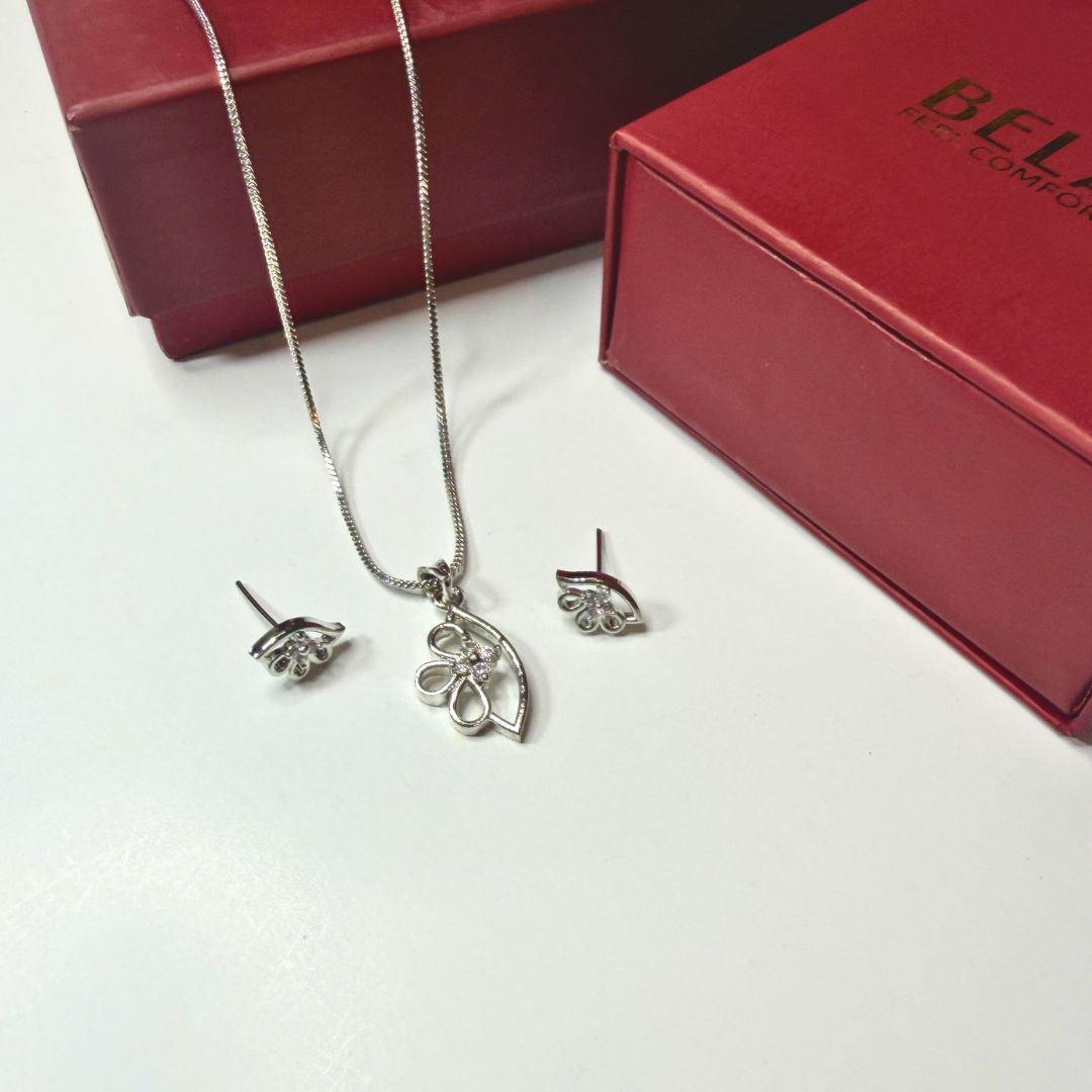 Silver necklace and earrings set with a red box in the background