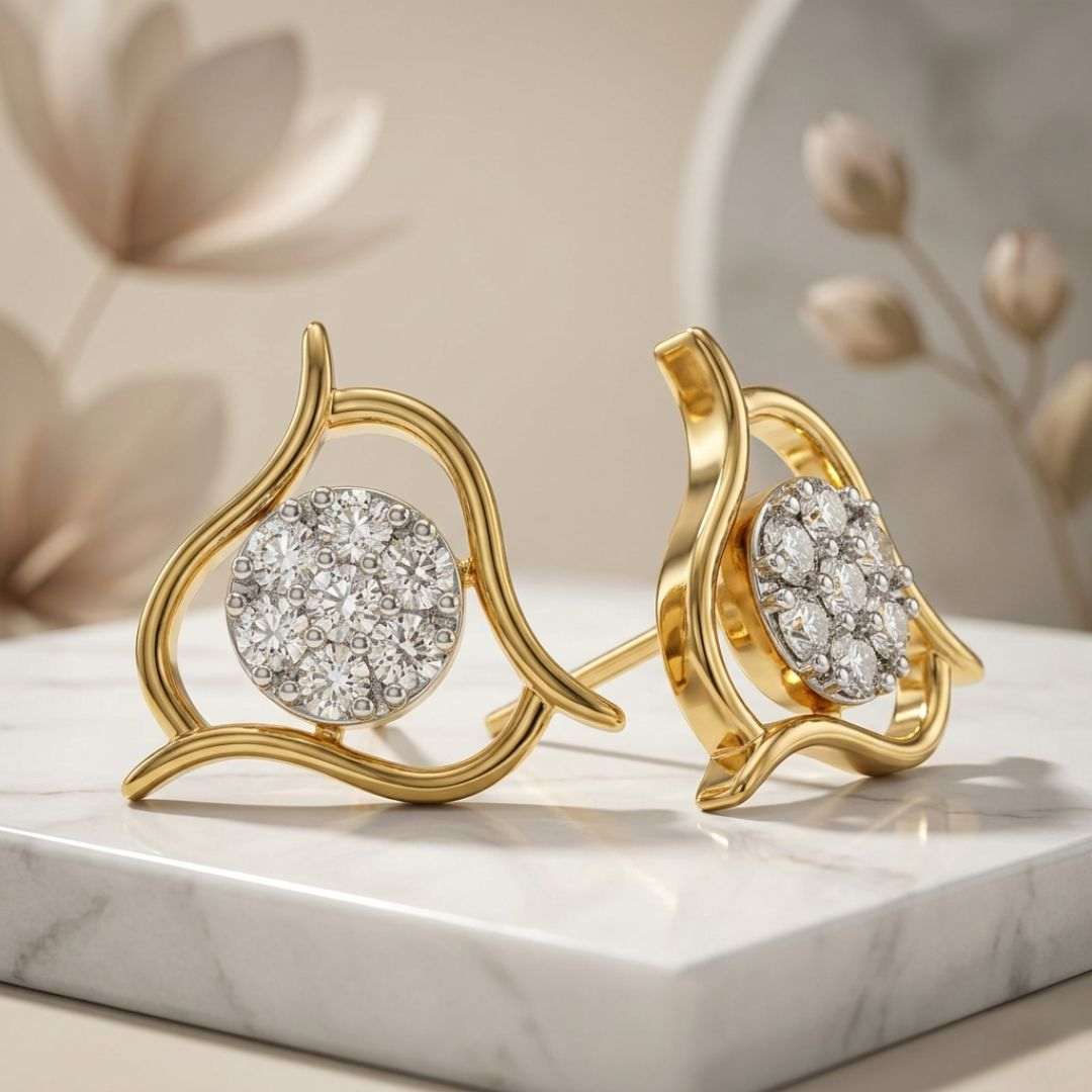 Gold earrings with diamond-like stones on a marble surface
