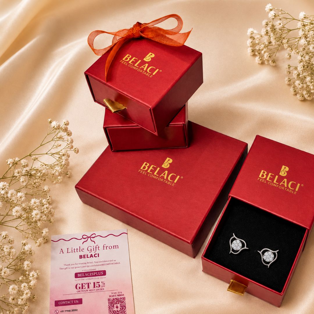 Red Belaci jewelry boxes with silver stud earrings and a discount card on a silk background