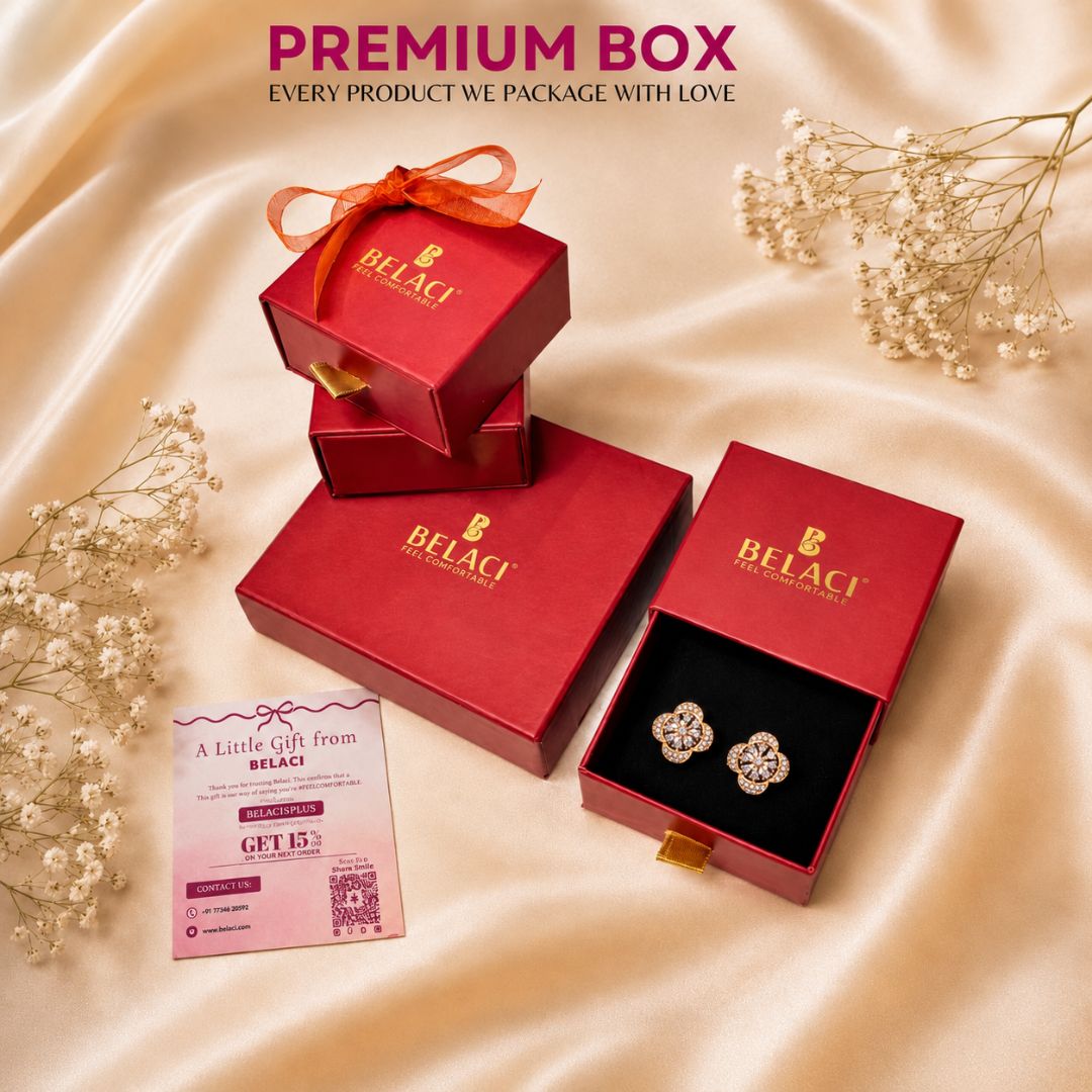 Red jewelry boxes with gold logo and flower shaped earrings on a satin background with a discount card