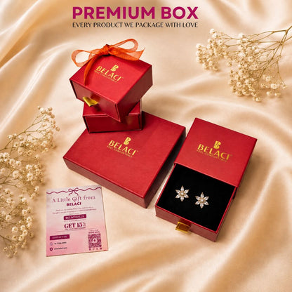 Red jewelry boxes with flower shaped earrings and a discount card on a silk background