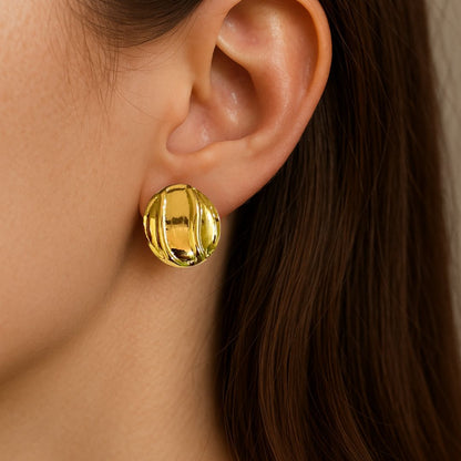 Gold earring worn by a person