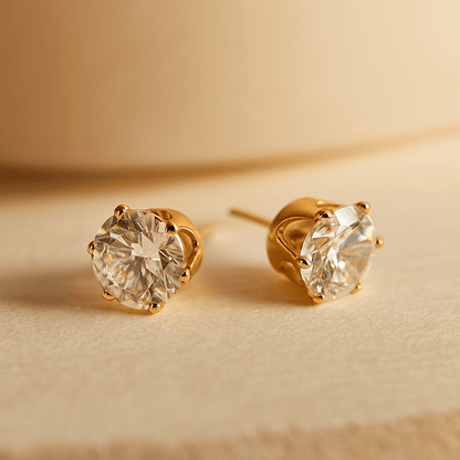 Gold stud Earrings for Women with clear gemstones on a beige background