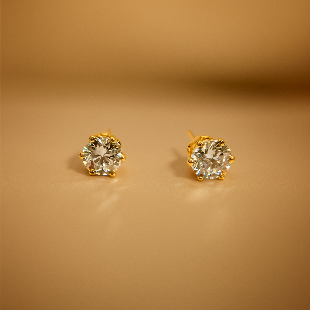 Gold Earrings for Women with clear gemstones on a beige background
