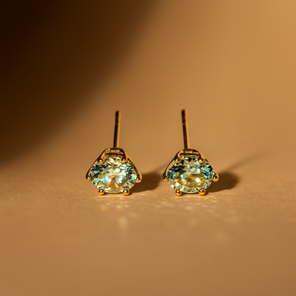 Pair of gold Earrings for Women with White gemstones on a brown background
