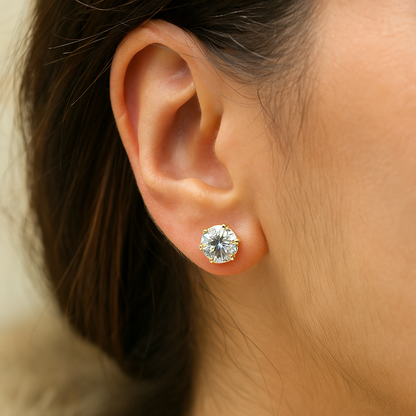 Close-up of an ear wearing a gold Earrings for Women with a clear gemstone.