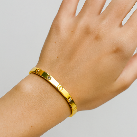 Gold Bracelet for Women with diamonds on a wrist against a light gray background