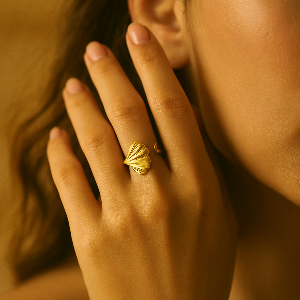 Close-up of a hand with a gold Ring for Women on a warm-toned background