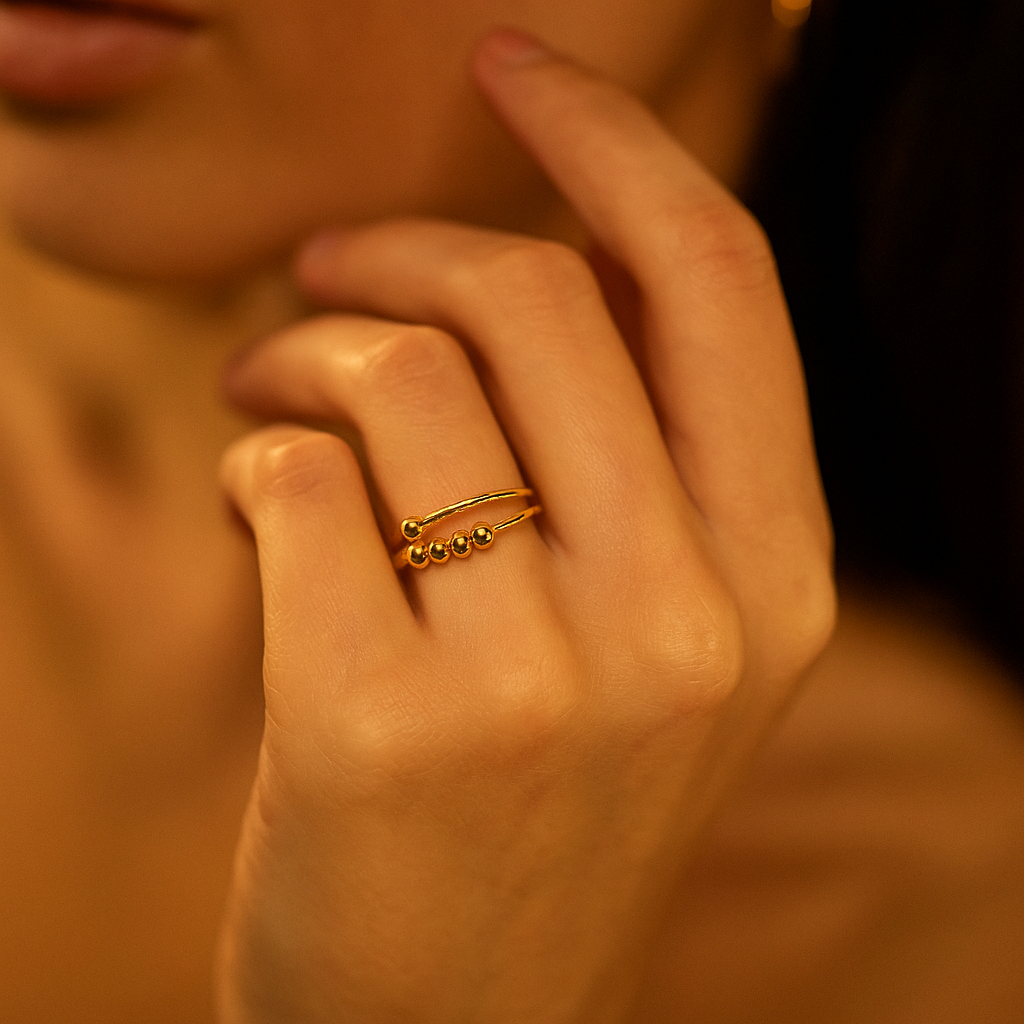 Close-up of a hand with a gold Ring for Women on a warm-toned background