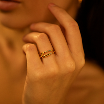 Close-up of a hand with a gold Ring for Women on a warm-toned background