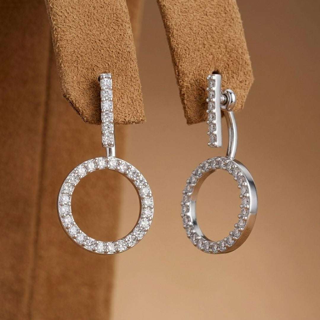 Silver hoop earrings with clear stones on a brown leather strap