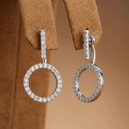 Silver hoop earrings with clear stones on a brown leather strap