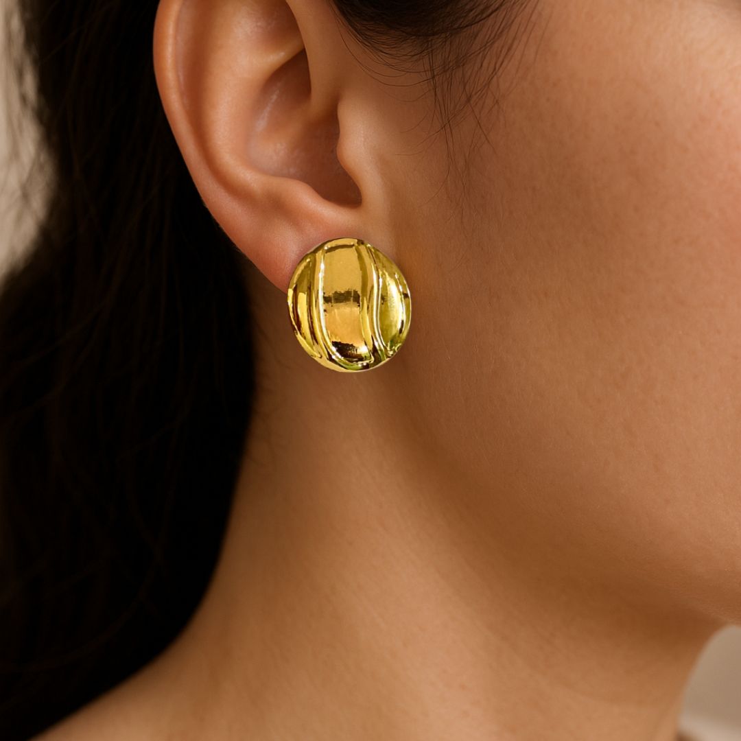 Gold earring worn by a person