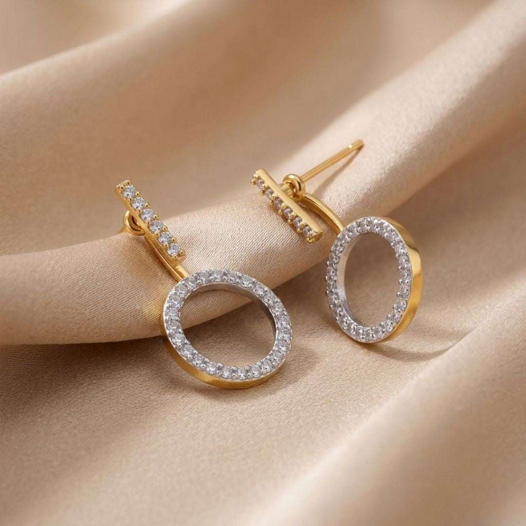 Gold and silver hoop earrings on a beige fabric background