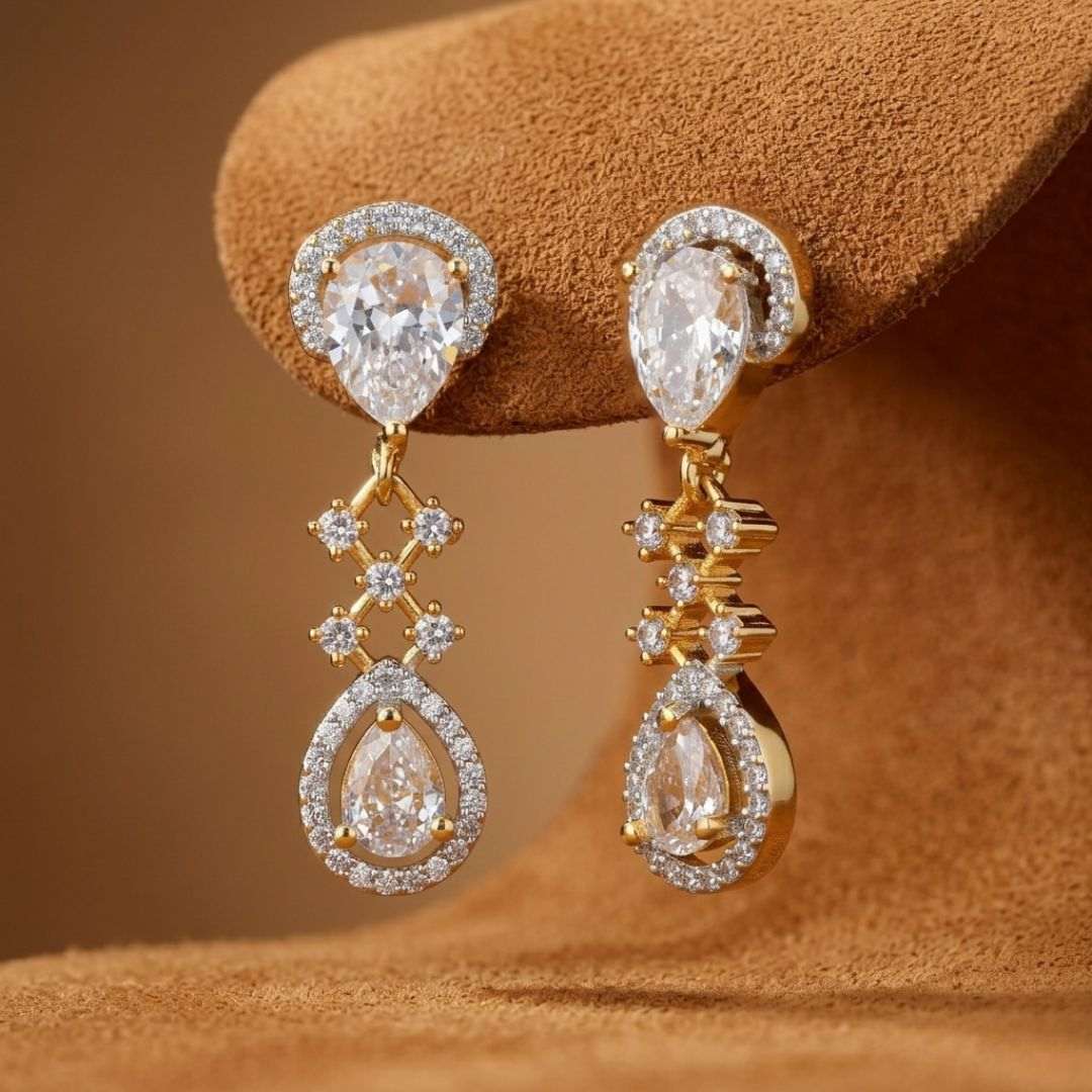 Gold and diamond earrings on a brown textured surface