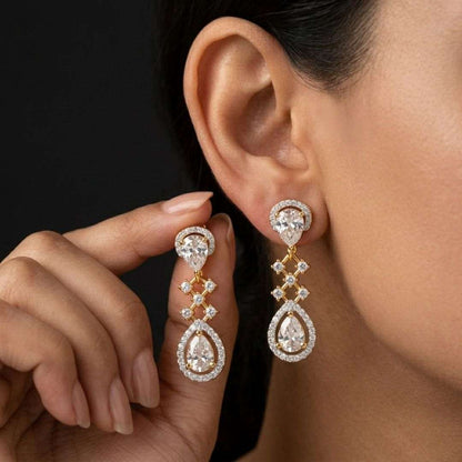 Close-up of a woman wearing sparkling diamond earrings with one hand adjusting them.