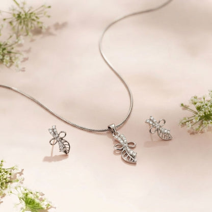 Silver necklace and matching stud earrings with leaf and bow design featuring small clear stones
