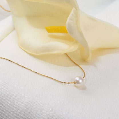 Gold Plated Pendant for Women on a white surface with a soft yellow fabric background