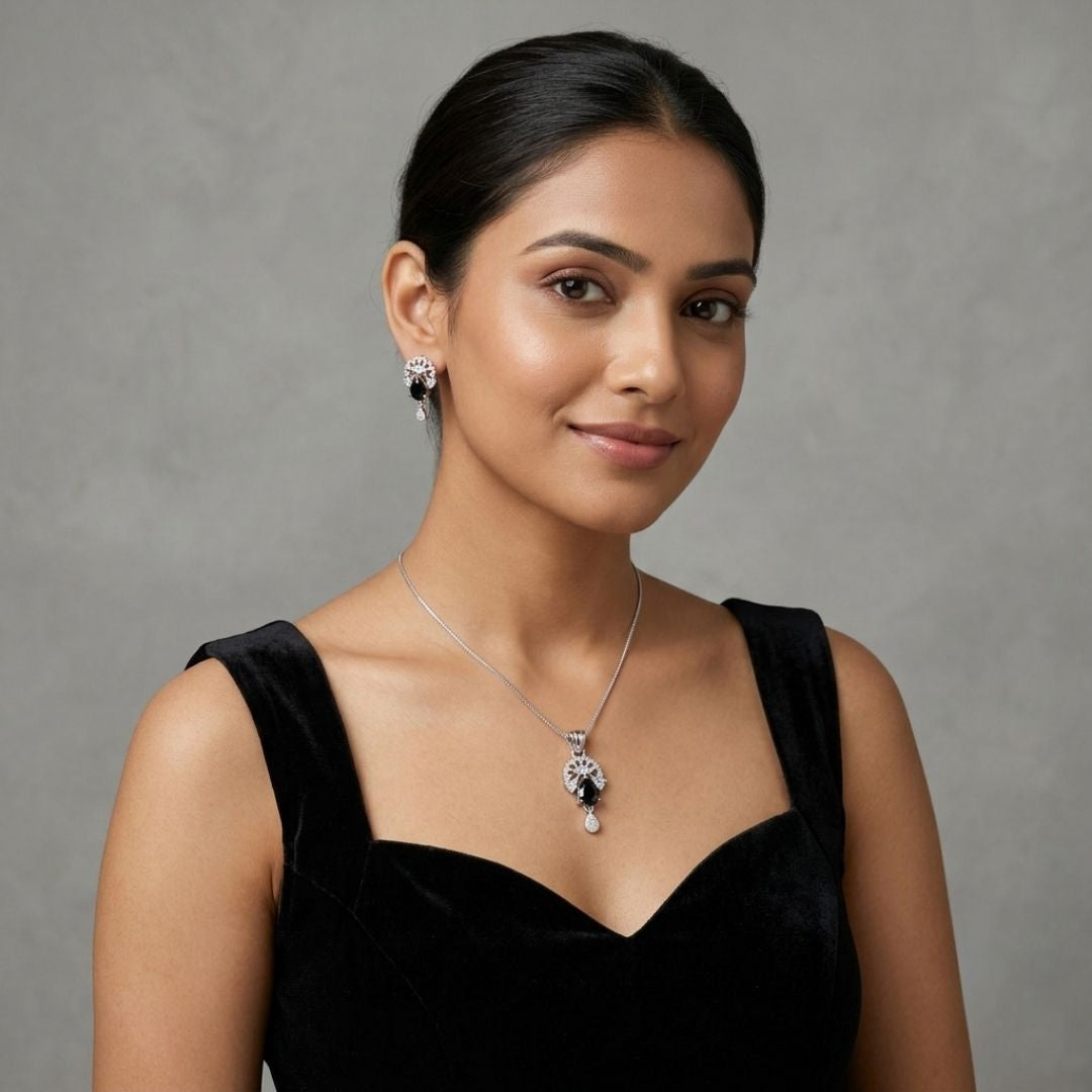 Woman wearing a silver necklace and matching earrings with black stones