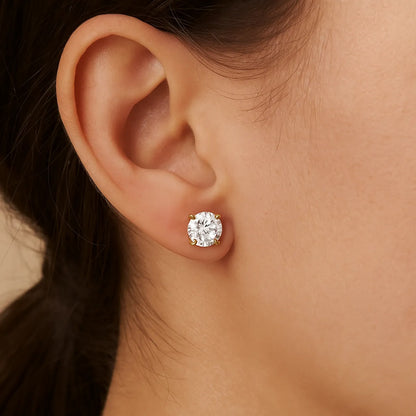 Close-up of an ear wearing a diamond stud earring with a neutral background