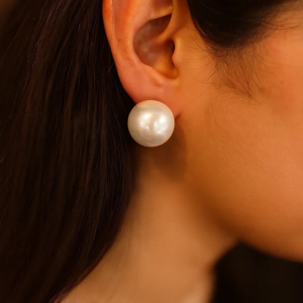Close-up of an ear wearing a pearl Earrings for Women with a blurred background