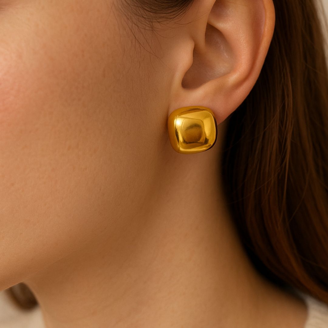 Gold earring worn by a person