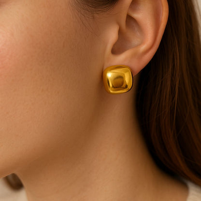 Gold earring worn by a person
