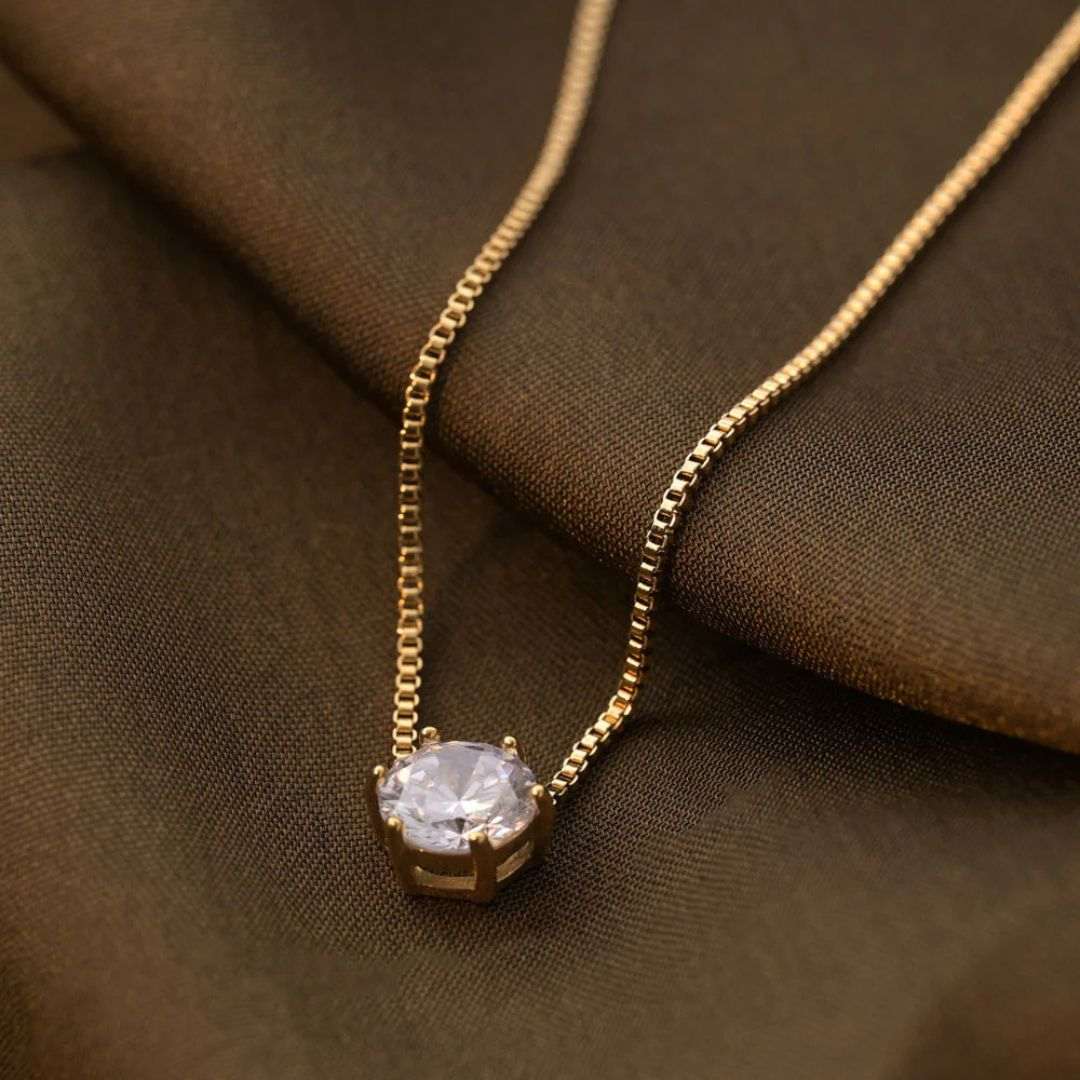 Gold Plated Pendant for Women with a single diamond pendant on a brown fabric background