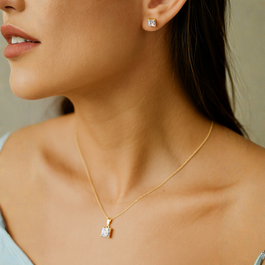 Gold Pendant for Women with a single pearl on a dark fabric background