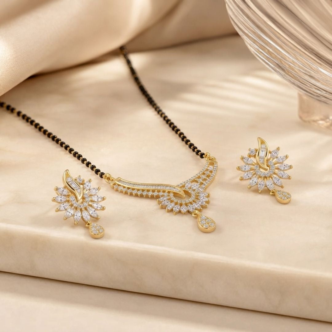 A beautifully designed mangalsutra featuring a curved gold-finished pendant adorned with sparkling American diamonds, accompanied by matching earrings.