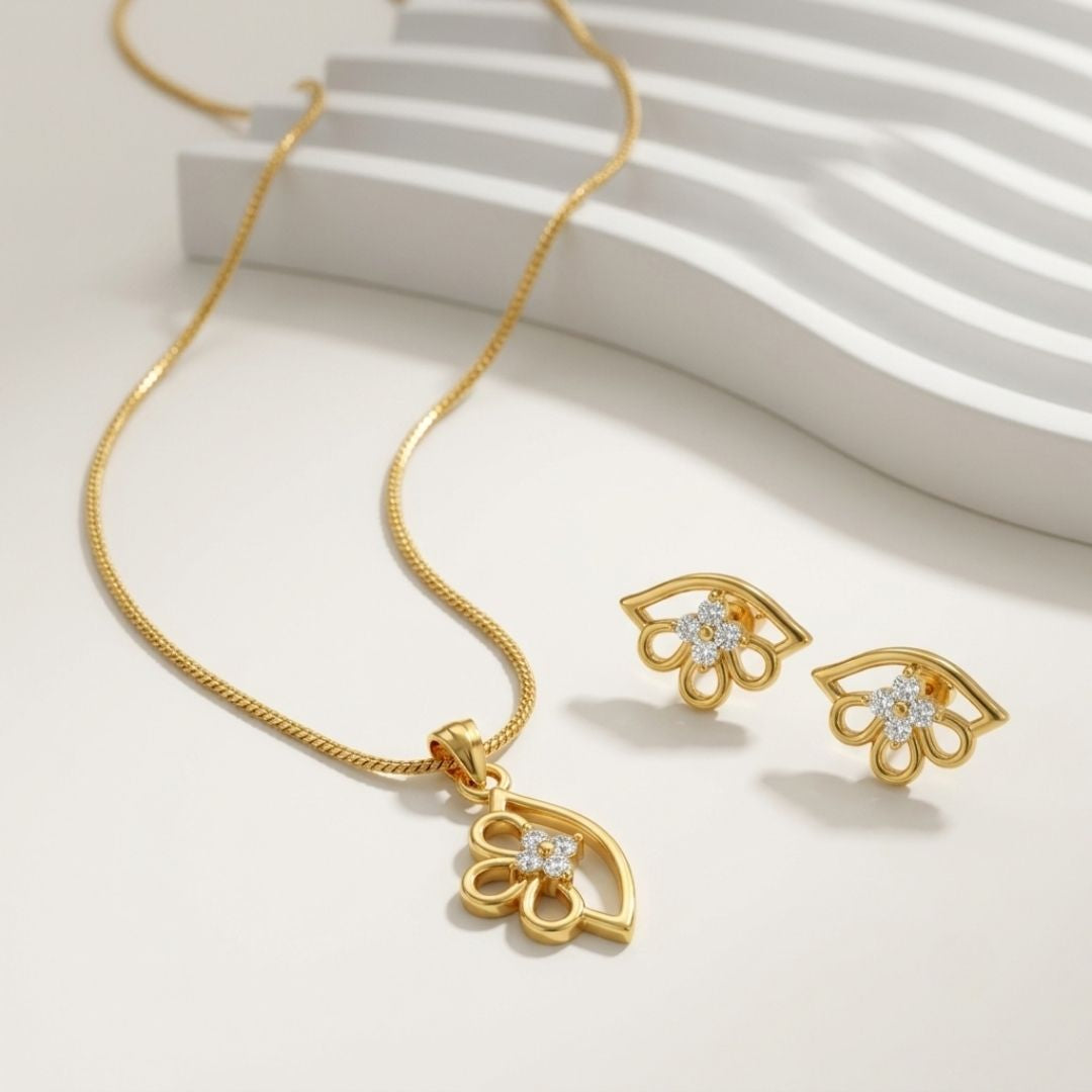 Gold necklace and matching stud earrings with flower shaped pendants featuring small white stones