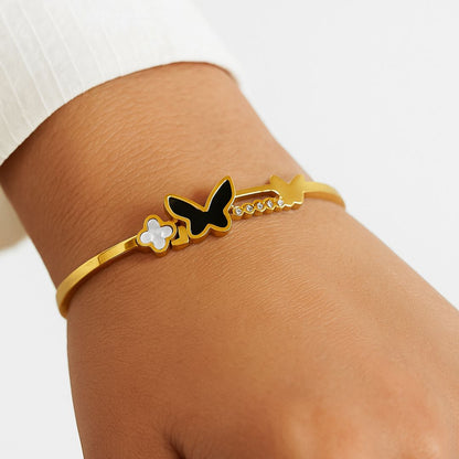 Gold Plated bracelet with butterfly design on a wrist against a white background