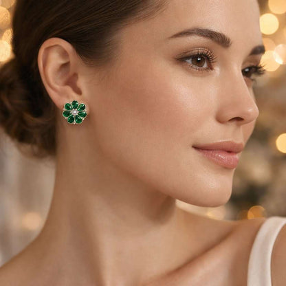 Close-up of a woman wearing emerald green floral earrings with a blurred background