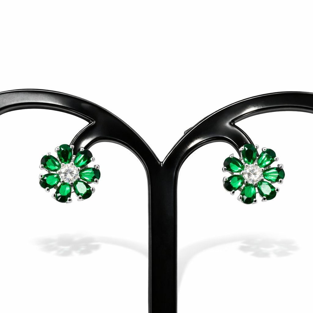 Pair of emerald and diamond AD Earrings for Women on a black stand with a white background