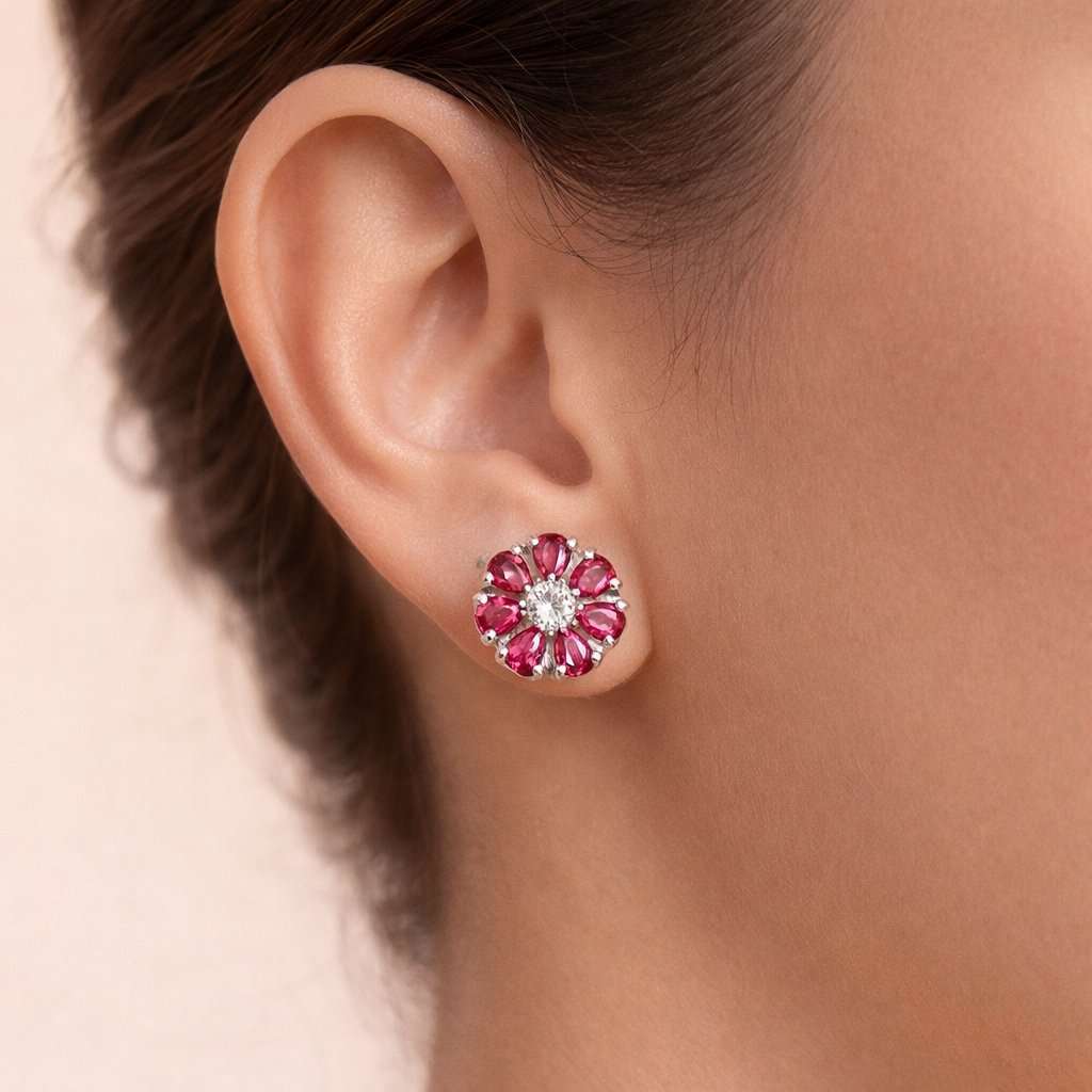 Close-up of an ear wearing a floral AD Earrings for Women with pink gemstones on a neutral background