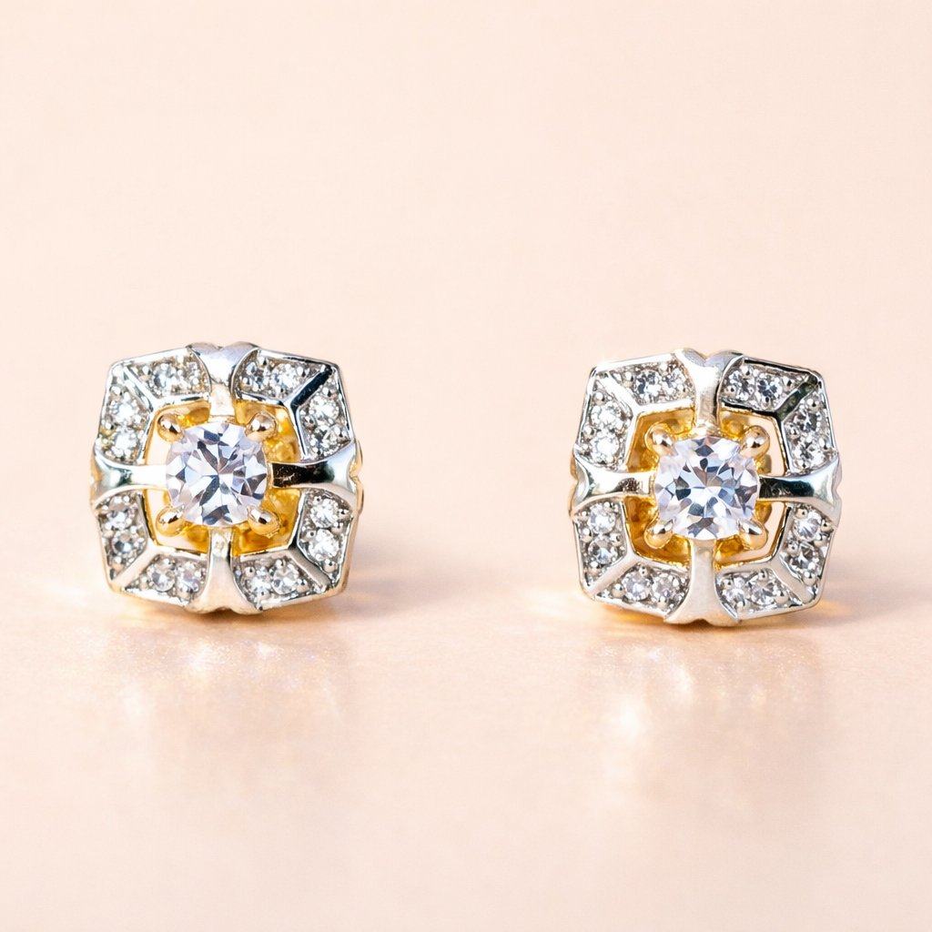 Pair of gold and silver AD Earrings for Women with clear gemstones on a beige background